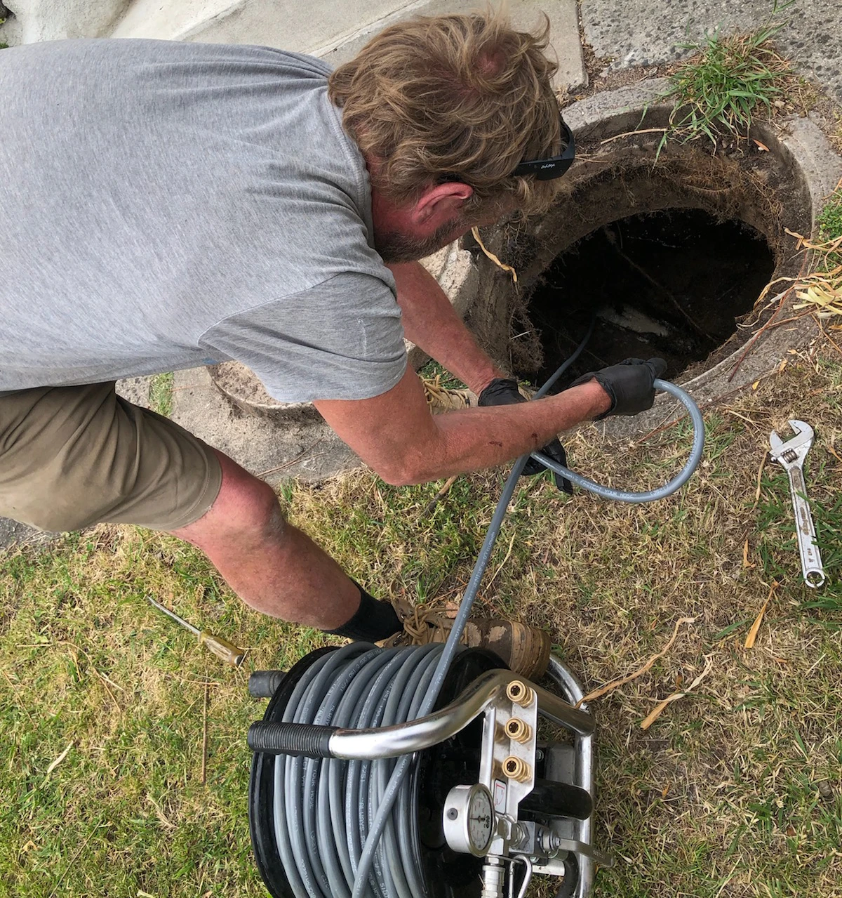 Simon feeding the water jetter into a drain